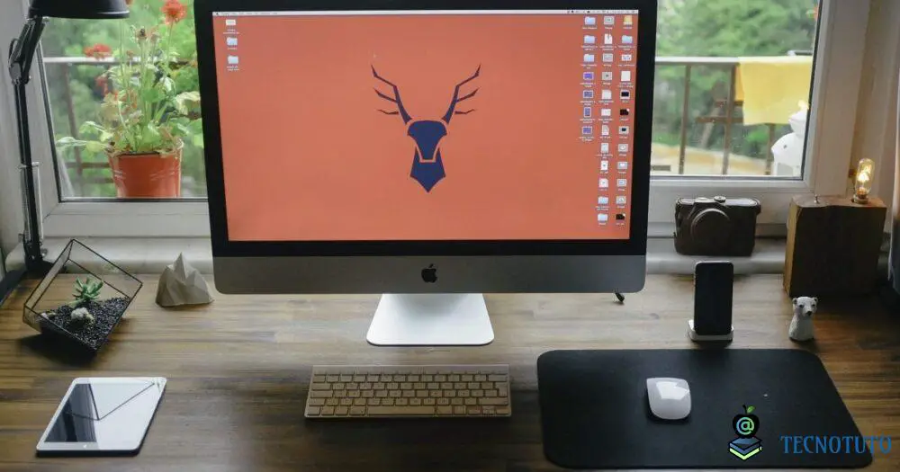 mac on desk next to ipad